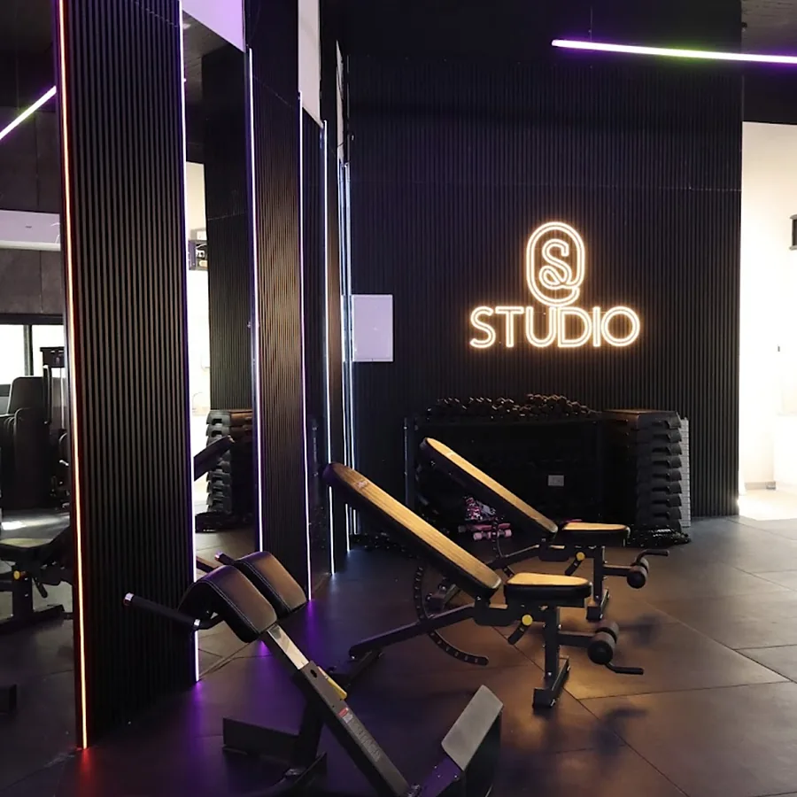 ספסלי אימון ושלט הניאון בחדר הכוח של Studio S