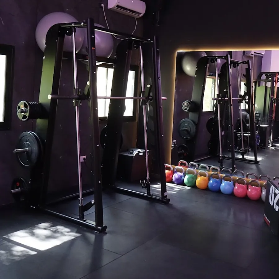 מכונת סמית וקטלבלים צבעוניים בחדר הכוח של Studio S